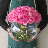 Pink roses in a fish bowl vase