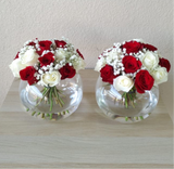 Red and white roses in a fish bowl vase