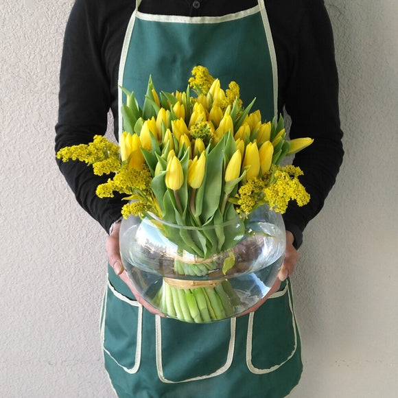 Yellow tulips in a fish bowl vase