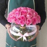 Pink roses in a fish bowl vase
