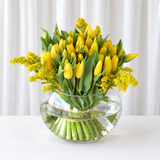 Yellow tulips in a fish bowl vase