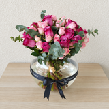 Assorted flowers in a fish bowl vase -purple