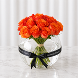 Orange roses in a fish bowl vase