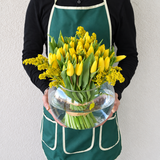 Yellow tulips in a fish bowl vase