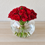 Red roses in a fish bowl vase