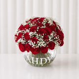 Red roses in a fish bowl vase
