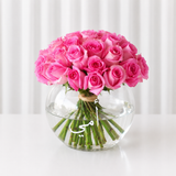 Pink roses in a fish bowl vase