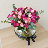 Assorted flowers in a fish bowl vase -purple