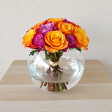 Purple and orange roses in a fish bowl vase