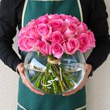 Pink roses in a fish bowl vase