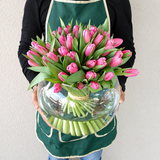 Purple tulips in a fish bowl vase