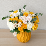 Assorted yellow and white flowers in a Yellow Vase