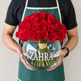 Red roses in a fish bowl vase