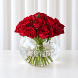 Red roses in a fish bowl vase