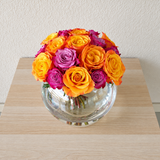 Purple and orange roses in a fish bowl vase