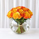 Orange roses in a fish bowl vase
