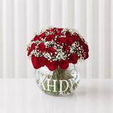 Red roses in a fish bowl vase