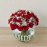 Red roses in a fish bowl vase