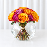 Purple and orange roses in a fish bowl vase