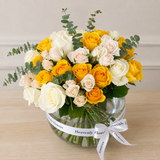 Assorted yellow and white flowers in a fish bowl