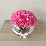 Pink roses in a fish bowl vase