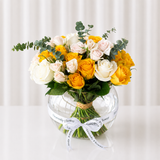 Assorted yellow and white flowers in a fish bowl