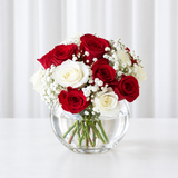 Red and white roses in a fish bowl vase