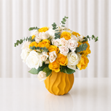 Assorted yellow and white flowers in a Yellow Vase