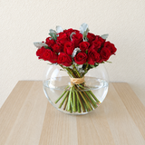 Red roses in a fish bowl vase