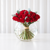 Red roses in a fish bowl vase