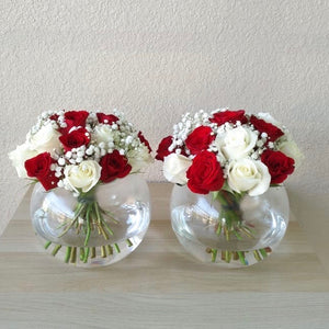 red and white roses in 2 fish bowl vases