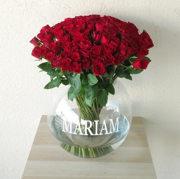 100 red roses in a fish bowl vase