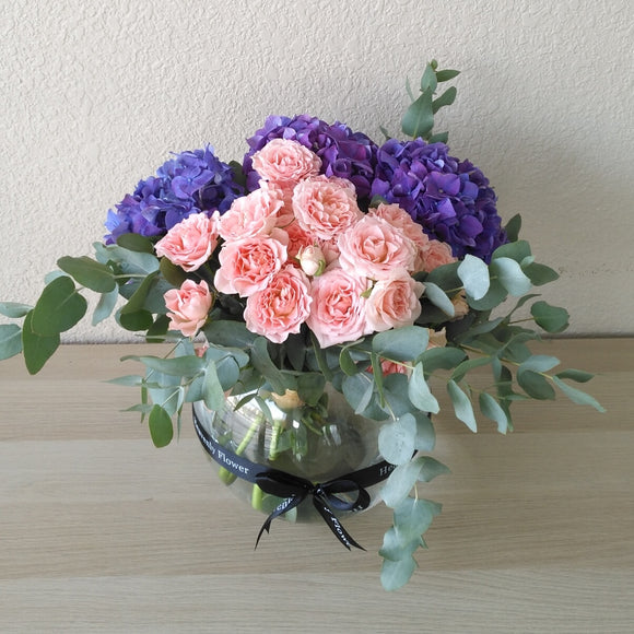 purple hydrangea and pink flowers in a fishbowl