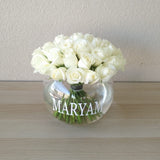 White roses in a fish bowl vase