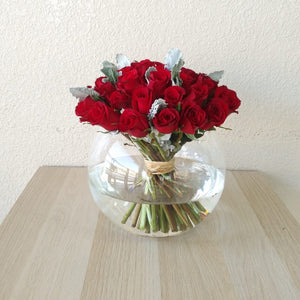 Red roses in a fish bowl vase