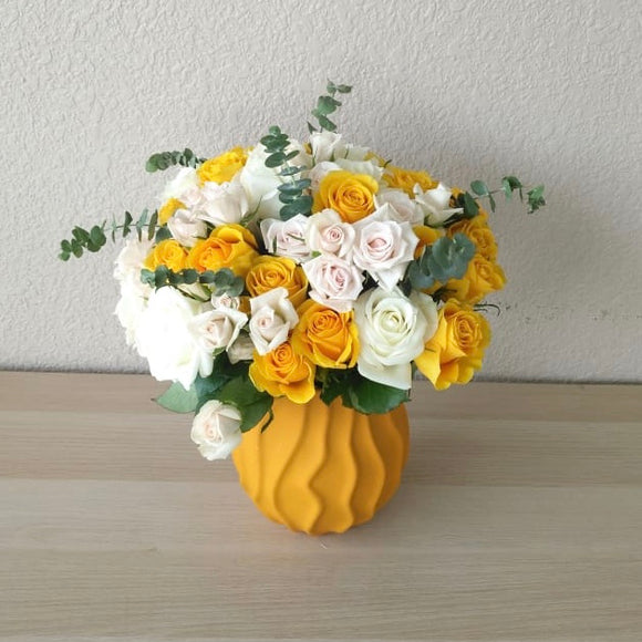 Assorted yellow and white flowers in a Yellow Vase