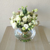 White flowers in a fish bowl vase