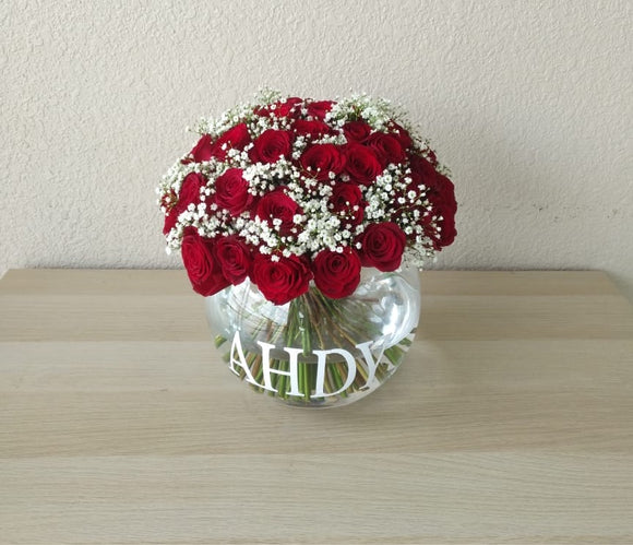 Red roses in a fish bowl vase