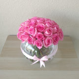 Pink roses in a fish bowl vase