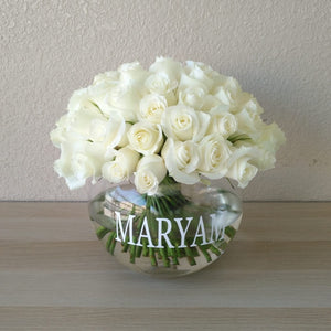 White roses in a fish bowl vase